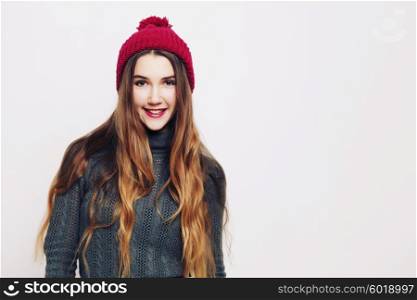 Beauty portrait of a young beautiful girl with long ombre straight hair wearing marsala color warm hat. Magnificent hair. Lips care. Young blonde hipster girl having fun