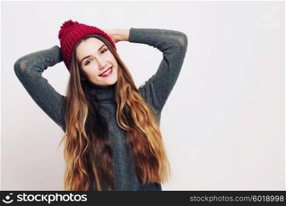 Beauty portrait of a young beautiful girl with long ombre straight hair wearing marsala color warm hat. Magnificent hair. Lips care. Young blonde hipster girl having fun