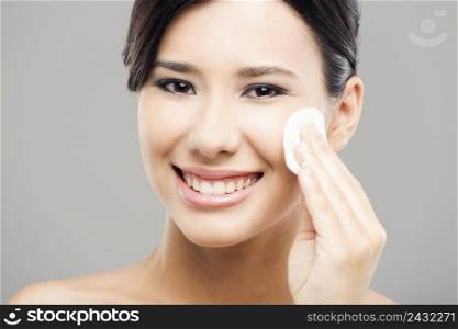 Beauty portrait of an Asian young woman cleaning the face with cotton