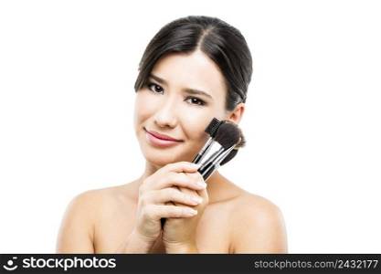 Beauty portrait of an Asian young woman holding make-up brushes