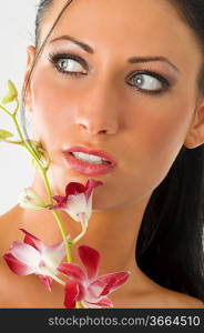 beauty portrait of cute woman with blue eyes and pink orchid