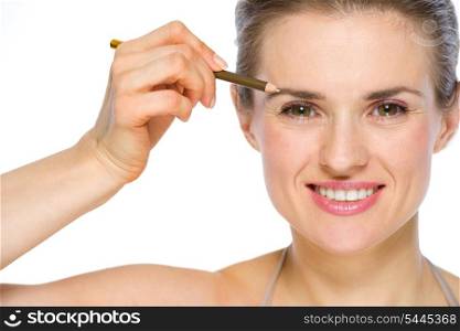 Beauty portrait of happy young woman applying brown eye liner
