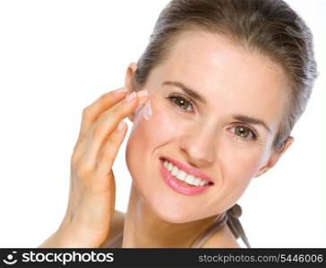 Beauty portrait of happy young woman applying creme