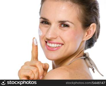 Beauty portrait of happy young woman showing creme on finger