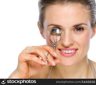 Beauty portrait of happy young woman using eyelash curler