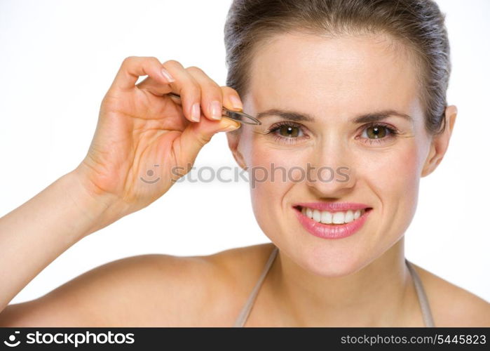 Beauty portrait of happy young woman using tweezers