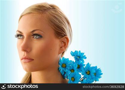 beauty portrait of pretty blond girl with blue daisy