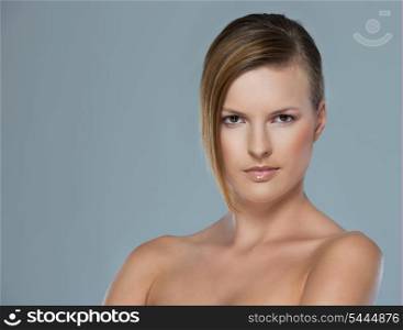 Beauty portrait of serous young woman isolated on gray