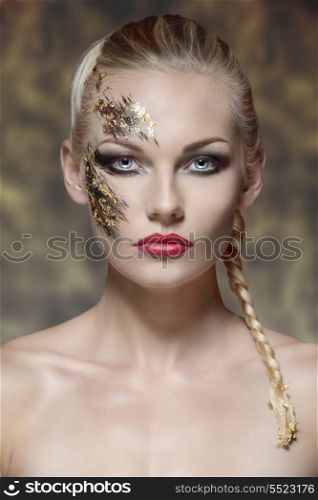 beauty portrait of sexy blonde girl with bride hair-style and strong original make-up on her face. Posing in front of the camera