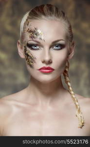 beauty portrait of sexy blonde girl with bride hair-style and strong original make-up on her face. Posing in front of the camera