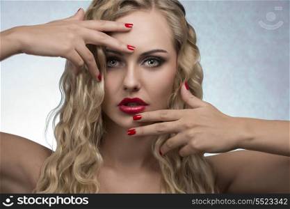 beauty portrait of sexy female with luxury red lipstick, nail polish and blonde wavy shiny hair-style