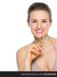 Beauty portrait of smiling young woman holding eyelash curler