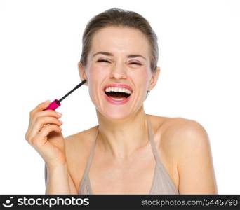 Beauty portrait of smiling young woman holding mascara brush