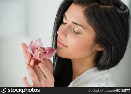 Beauty portrait of young, attractive, fresh, healthy and natural woman holding the lily flower