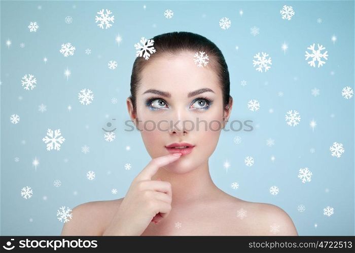 Beauty portrait of young beautiful woman over snowy. Christmas background. New yaer holidays and people concept