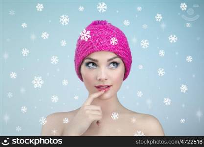 Beauty portrait of young beautiful woman over snowy. Christmas background. New yaer holidays and people concept. Girl in winter hat