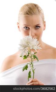 beauty portrait of young cute blond girl with white top and some flowers near face . wellness concept