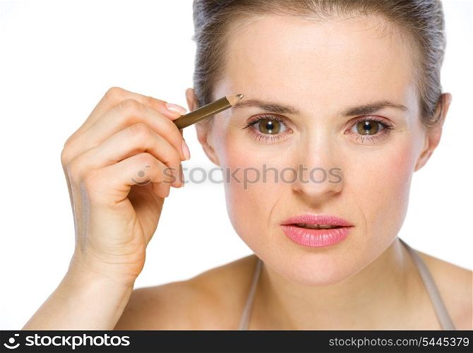 Beauty portrait of young woman applying brown eye liner
