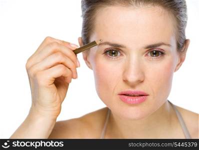Beauty portrait of young woman applying brown eye liner