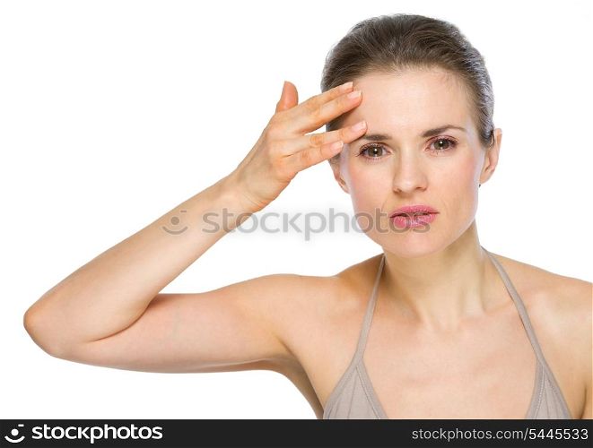 Beauty portrait of young woman checking facial skin