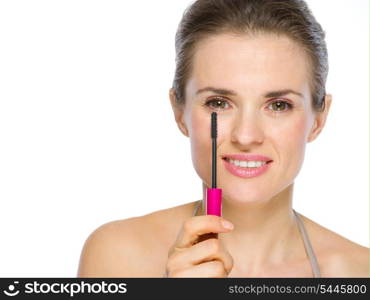 Beauty portrait of young woman holding mascara brush