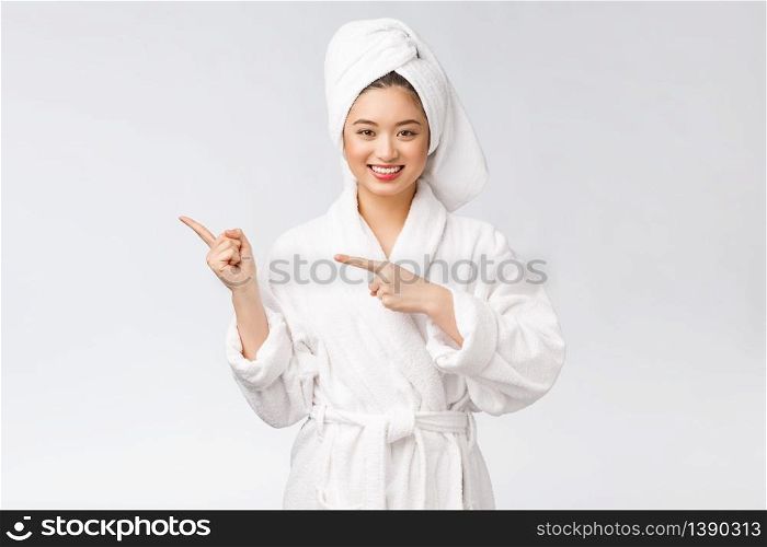 Beauty portrait of young woman showing and pointing finger to empty copy space, asian beauty in bathrobe. Beauty portrait of young woman showing and pointing finger to empty copy space, asian beauty in bathrobe.