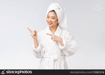 Beauty portrait of young woman showing and pointing finger to empty copy space, asian beauty in bathrobe. Beauty portrait of young woman showing and pointing finger to empty copy space, asian beauty in bathrobe.