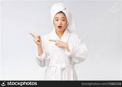 Beauty portrait of young woman showing and pointing finger to empty copy space, asian beauty in bathrobe. Beauty portrait of young woman showing and pointing finger to empty copy space, asian beauty in bathrobe.