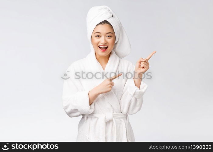 Beauty portrait of young woman showing and pointing finger to empty copy space, asian beauty in bathrobe. Beauty portrait of young woman showing and pointing finger to empty copy space, asian beauty in bathrobe.