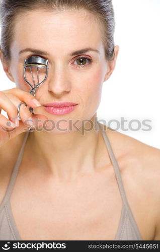 Beauty portrait of young woman using eyelash curler