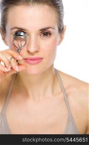 Beauty portrait of young woman using eyelash curler
