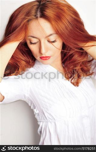 Beauty portrait. Red haired model with wavy soft hair close up