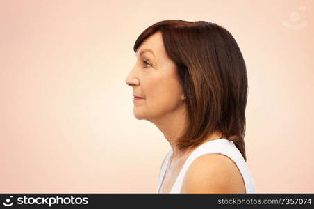 beauty, rhinoplasty and old people concept - profile of senior woman over beige background. profile of senior woman over white background