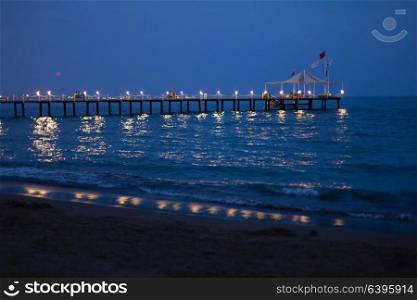Beauty romantic pier with bright lightening during the beautiful summer night. Romantic pier at night