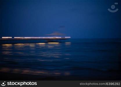Beauty romantic pier with bright lightening during the beautiful summer night. Romantic pier at night