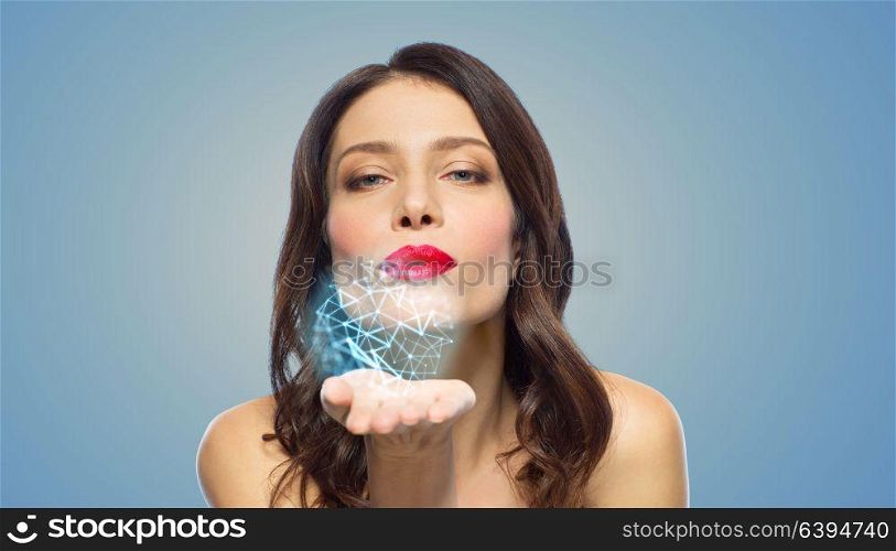 beauty, science and nano technology concept - beautiful woman with red lipstick blowing to low poly shape projection on her palm. beautiful woman blowing to low poly projection