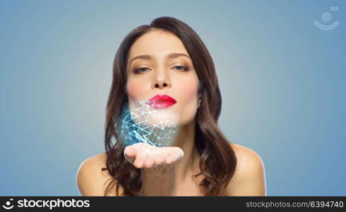 beauty, science and nano technology concept - beautiful woman with red lipstick blowing to low poly shape projection on her palm. beautiful woman blowing to low poly projection