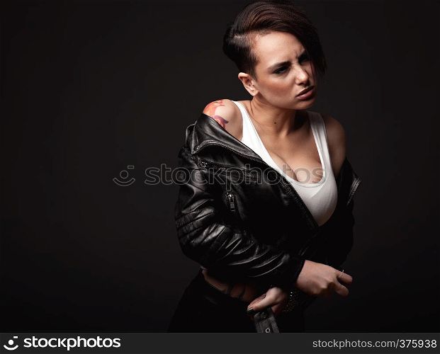 Beauty sexy woman in a leather jacket. Portrait on a dark background. Portrait of sexy caucasian woman