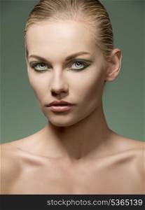 beauty shoot of very sensual blonde girl with naked shoulders, pure visage skin and creative green make-up