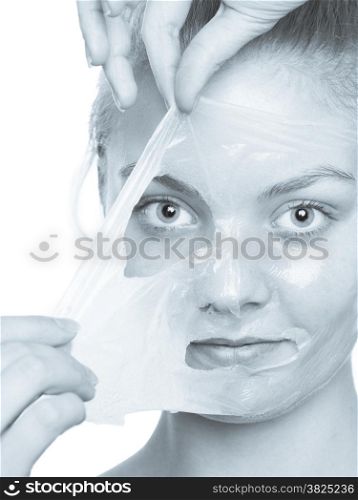 Beauty skin care cosmetics and health concept. Closeup young woman face, girl removing facial peel off mask isolated on white. Peeling. Selenium toned