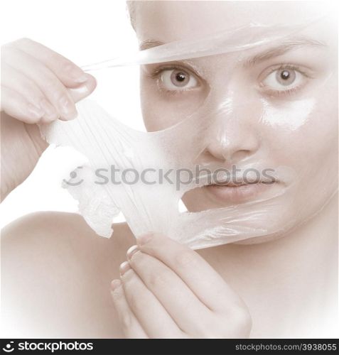 Beauty skin care cosmetics and health concept. Closeup young woman face, girl removing facial peel off mask isolated on white. Peeling.