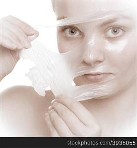 Beauty skin care cosmetics and health concept. Closeup young woman face, girl removing facial peel off mask isolated on white. Peeling.
