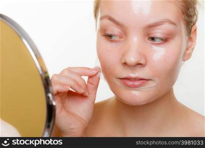 Beauty skin care cosmetics and health concept. Young woman face, girl removing facial peel off mask. Peeling.. Woman removing facial peel off mask.