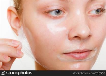 Beauty skin care cosmetics and health concept. Young woman face, girl removing facial peel off mask. Peeling.. Woman removing facial peel off mask.
