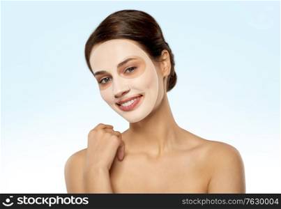 beauty, skin hydration and people concept - happy smiling young woman with hydrogel mask on face over blue background. beautiful young woman with hydrogel mask on face