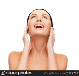 beauty, spa and health concept - laughing young woman looking up