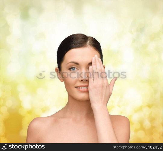beauty, spa and health concept - smiling young woman covering half of face with hand