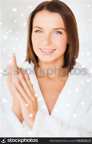 beauty, spa and people concept - beautiful woman in bathrobe over snowy background