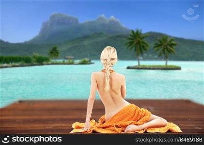 beauty, spa and travel concept - bare woman with towel over bora bora background. bare woman with towel over bora bora background