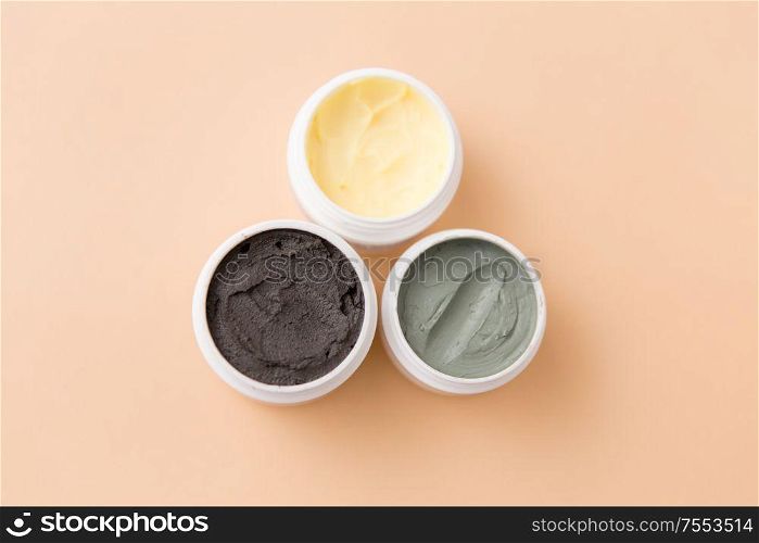 beauty, spa and wellness concept - blue clay mask, body butter and therapeutic mud on beige background. blue clay mask, body butter and therapeutic mud